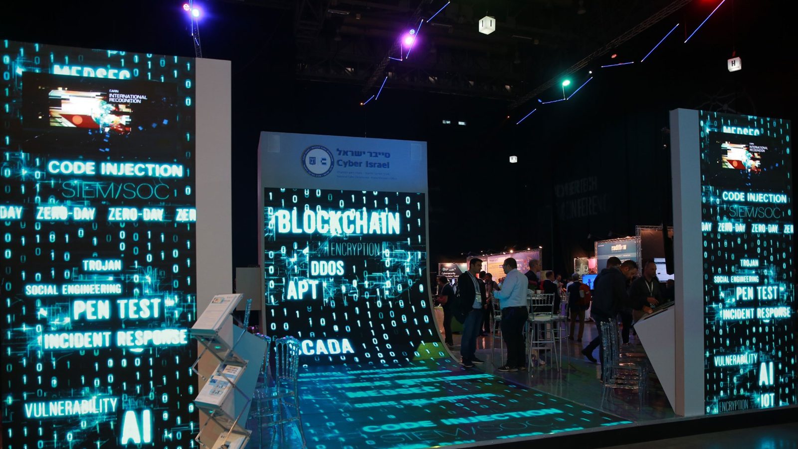 A cyber-themed stand whose LED wall curves at its base and carries on as an illuminated floor, code graphics running unbroken across both.