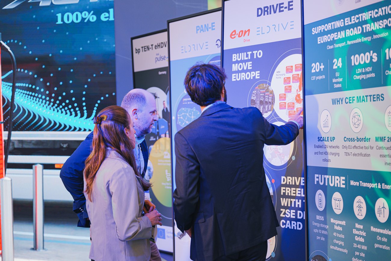 Visitors at a partner panel, one pointing to a corridor on the map.