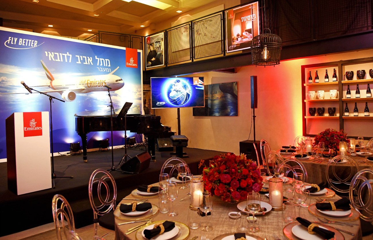 The gala room, long tables, copper rings overhead and a grand piano to one side.