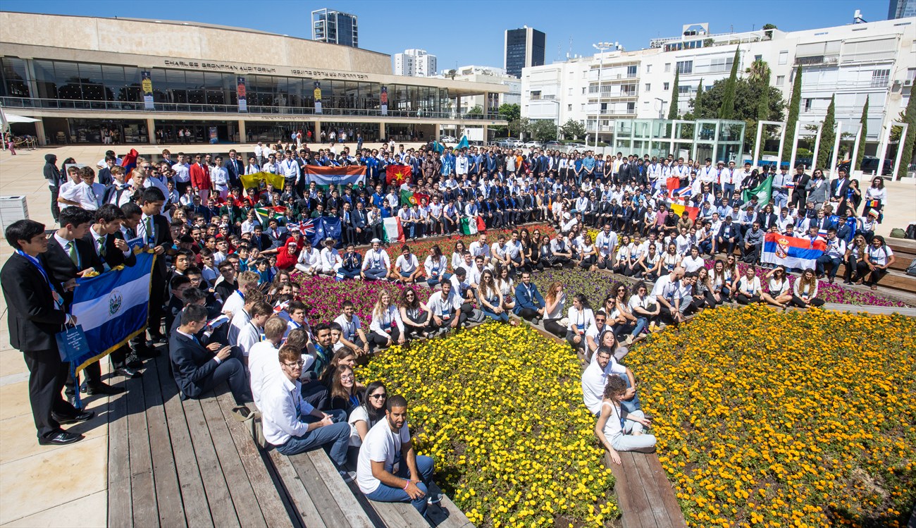 Delegations gathered outdoors on a planted plaza.