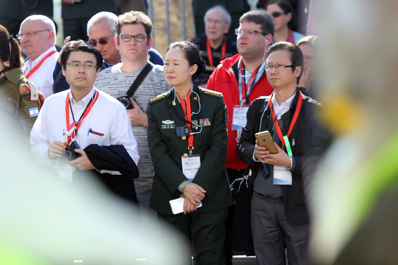 Delegates standing outdoors, lanyards around their necks.