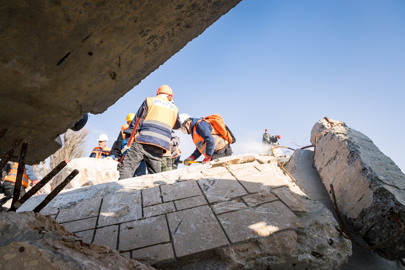 A search and rescue team working on a slab of broken concrete.