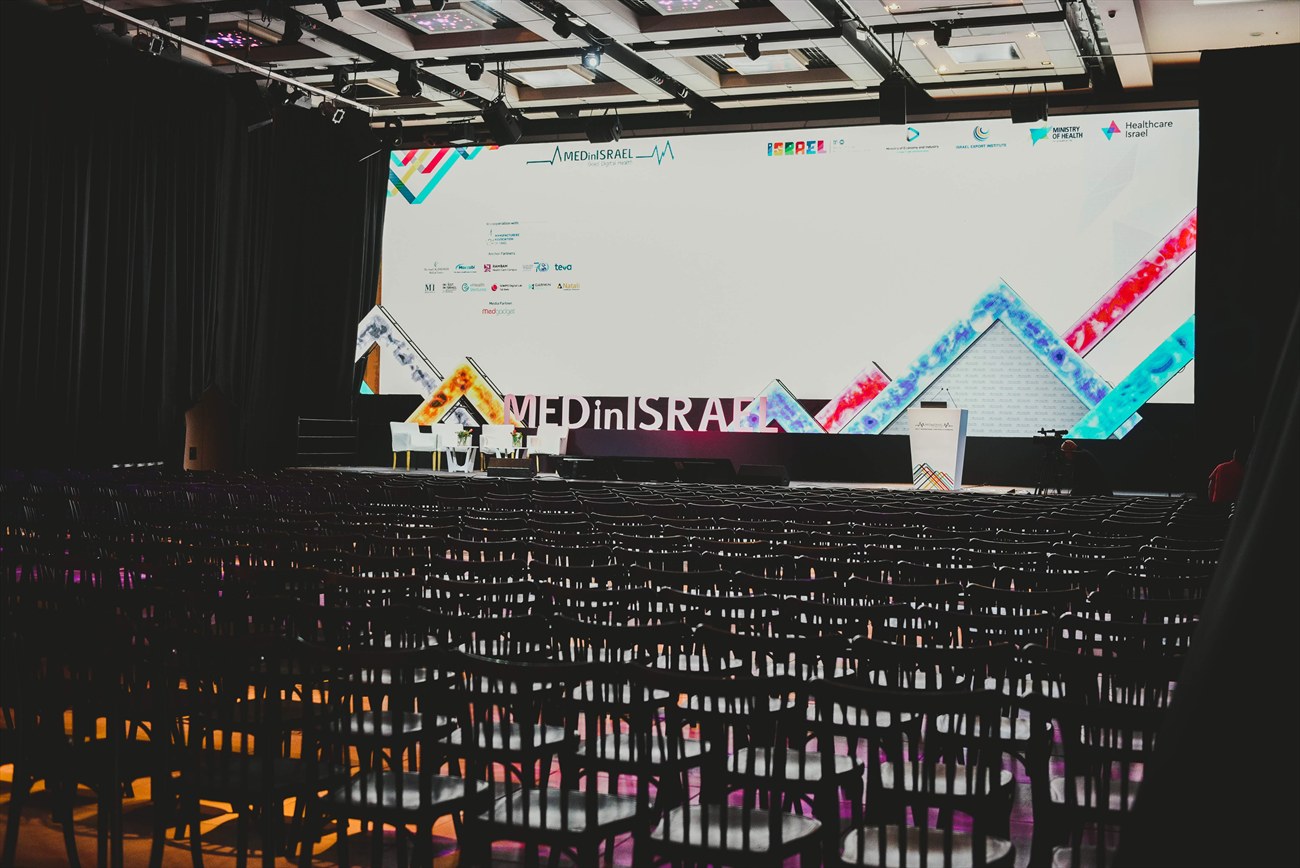 Plenary seating facing a wide lit screen.