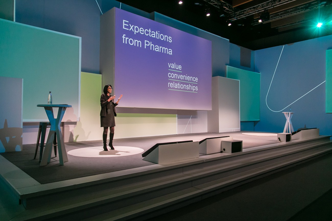 A second stage set in teal, with a lectern and seating in front of it.