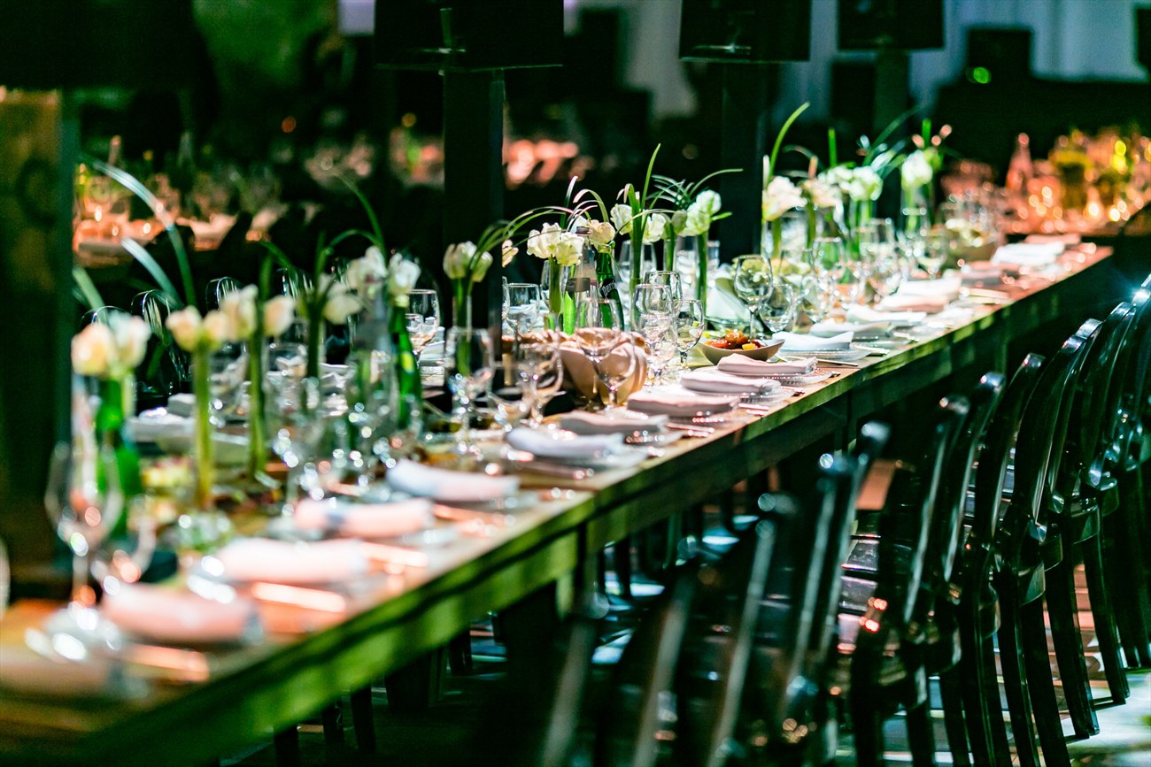 Long banquet tables running the length of the room, set for the gala.